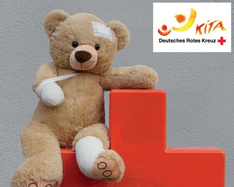 Kleiner bandagierter Teddy auf rotem Kreuz